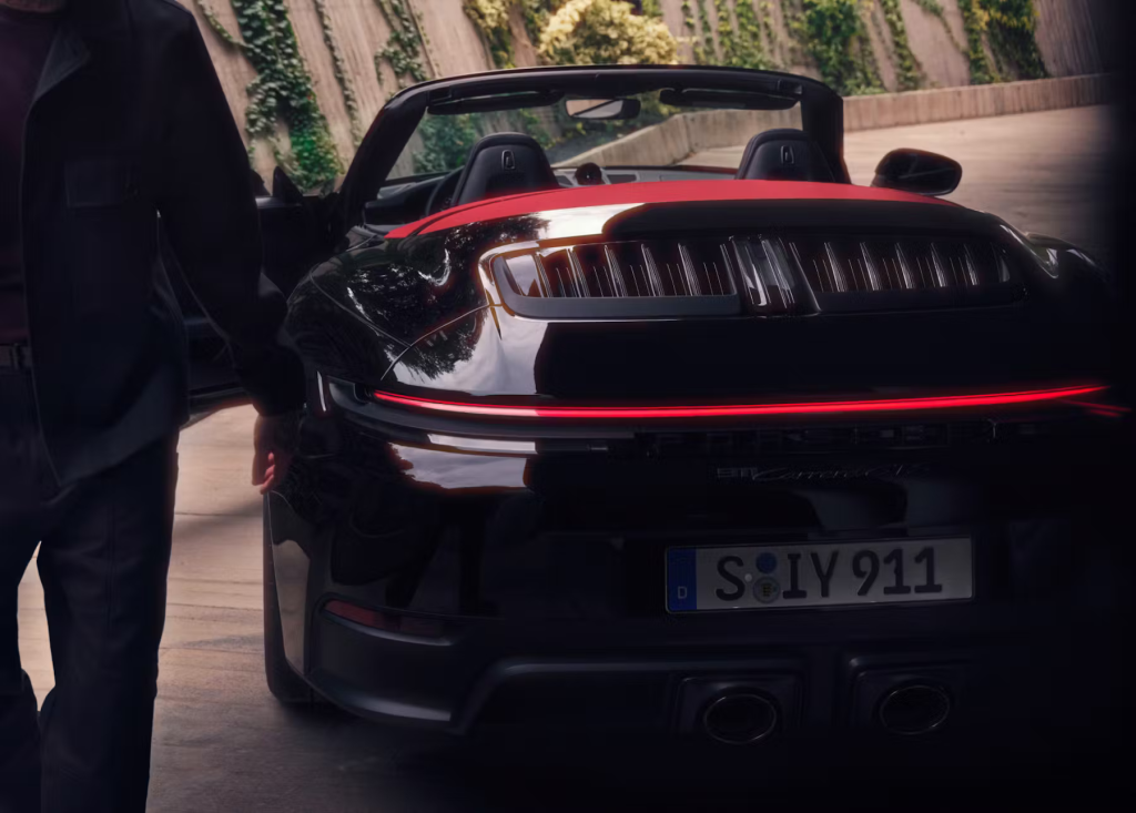 Luxury Porsche 911 Cabriolet parked near a calm lake with vibrant autumn leaves in Chicago’s countryside.