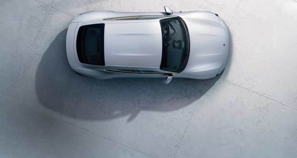 Porsche Taycan driving along The Morton Arboretum Loop in Lisle, Illinois, surrounded by golden autumn trees.