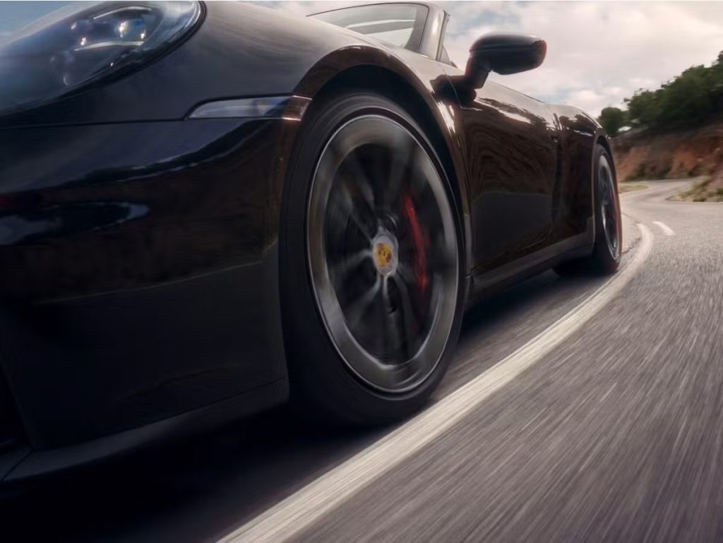 Porsche sports car on the road symbolizing the joy of ownership for both new and Certified Pre-Owned Porsche buyers.