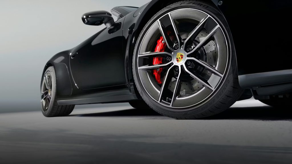 Close-up of a Porsche 911 wheel and brake caliper, emphasizing stability that helps the Porsche 911 define the modern sports car.