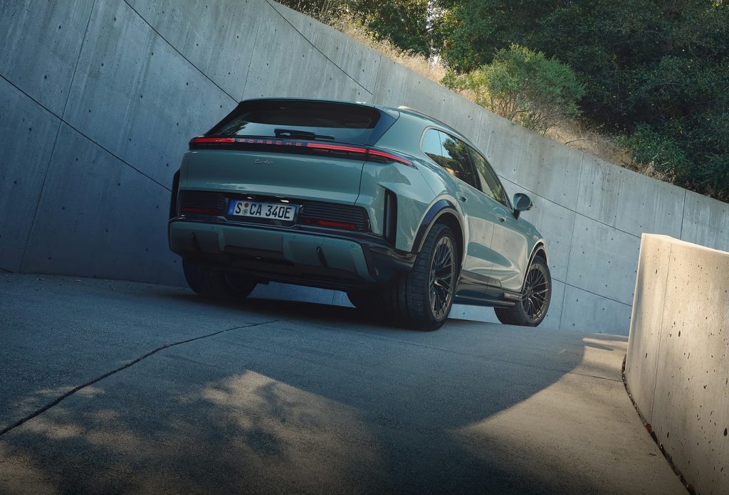 Rear view of a Porsche Cayenne Turbo driving uphill, highlighting the benchmark luxury performance SUV lineup.