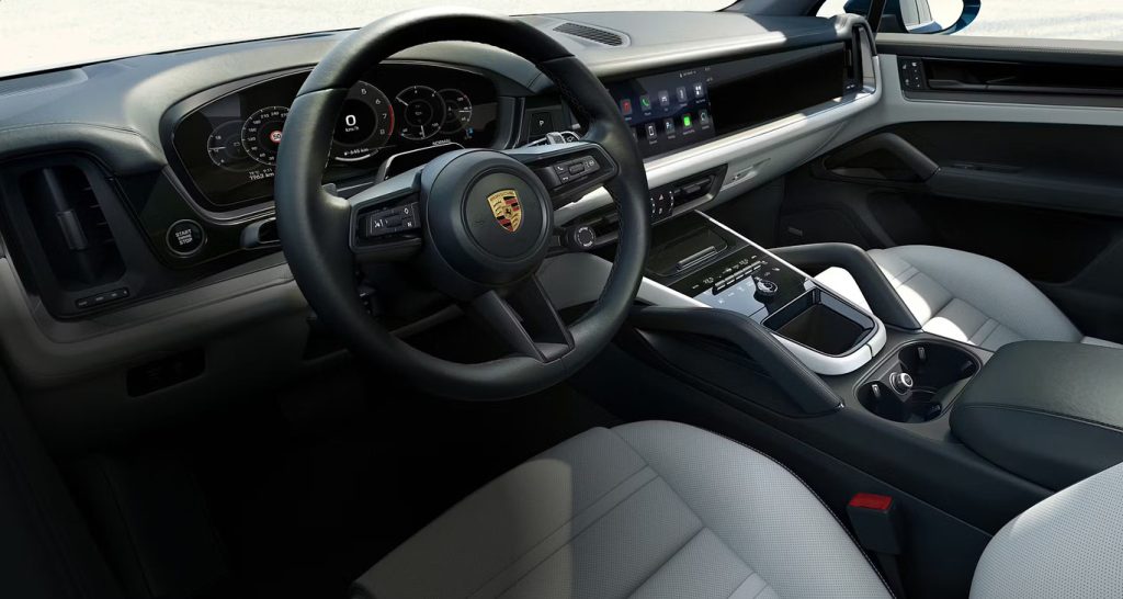 Interior of the Porsche Cayenne with steering wheel, digital display, and center console, reflecting the premium design of a luxury performance SUV.