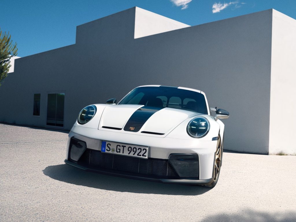 Front three-quarter view of a white Porsche 911 with aggressive styling details, highlighting Porsche’s next 911 and its pure driving pleasure appeal.