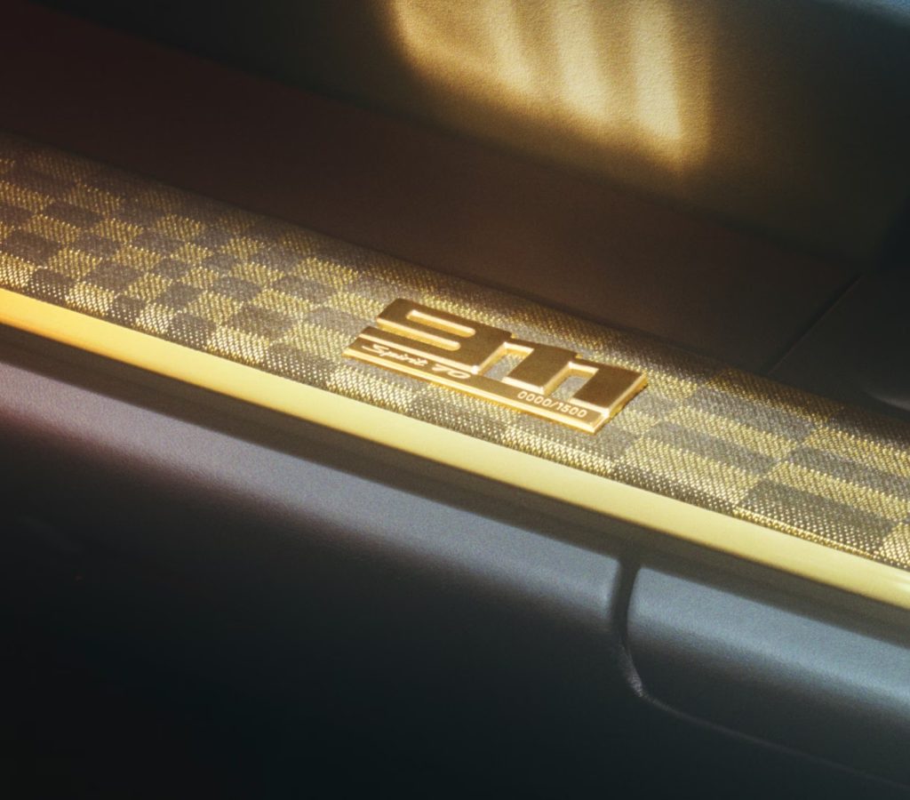 Close-up of a 2026 Porsche 911 interior badge and trim detail, symbolizing the hybrid performance evolution of the legendary sports car.