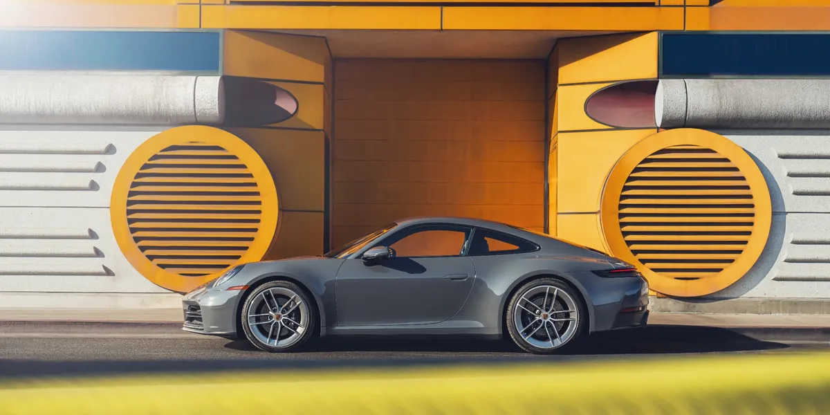 Cockpit view of 2026 Porsche 911 Carrera showing digital gauge cluster and steering wheel.