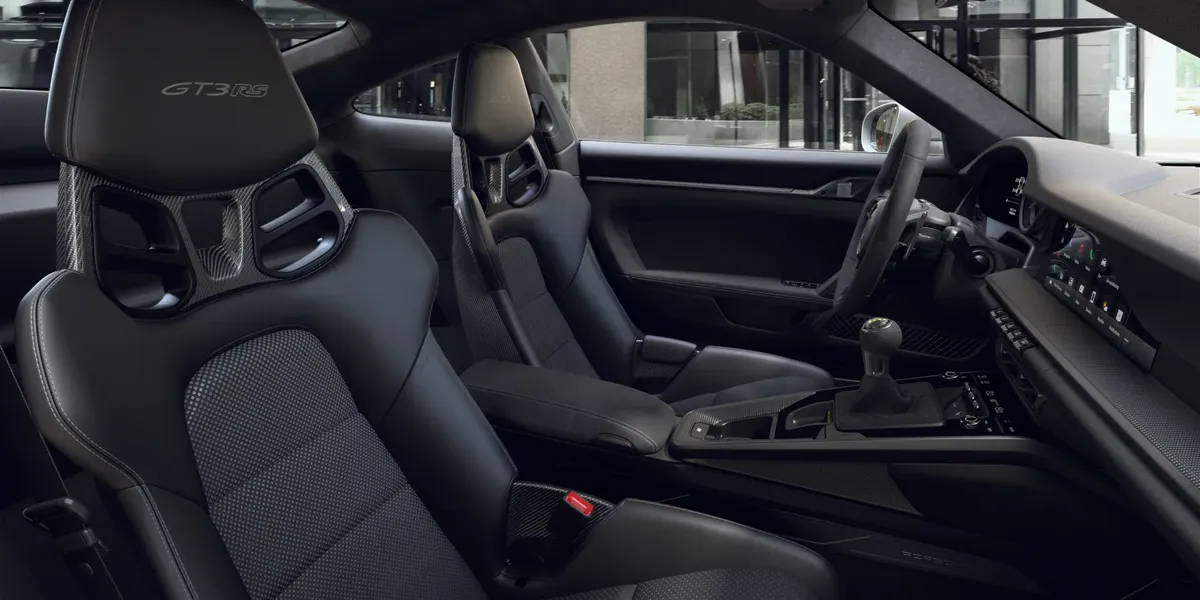 Cockpit view of 2026 Porsche 911 Carrera showing digital gauge cluster and steering wheel.