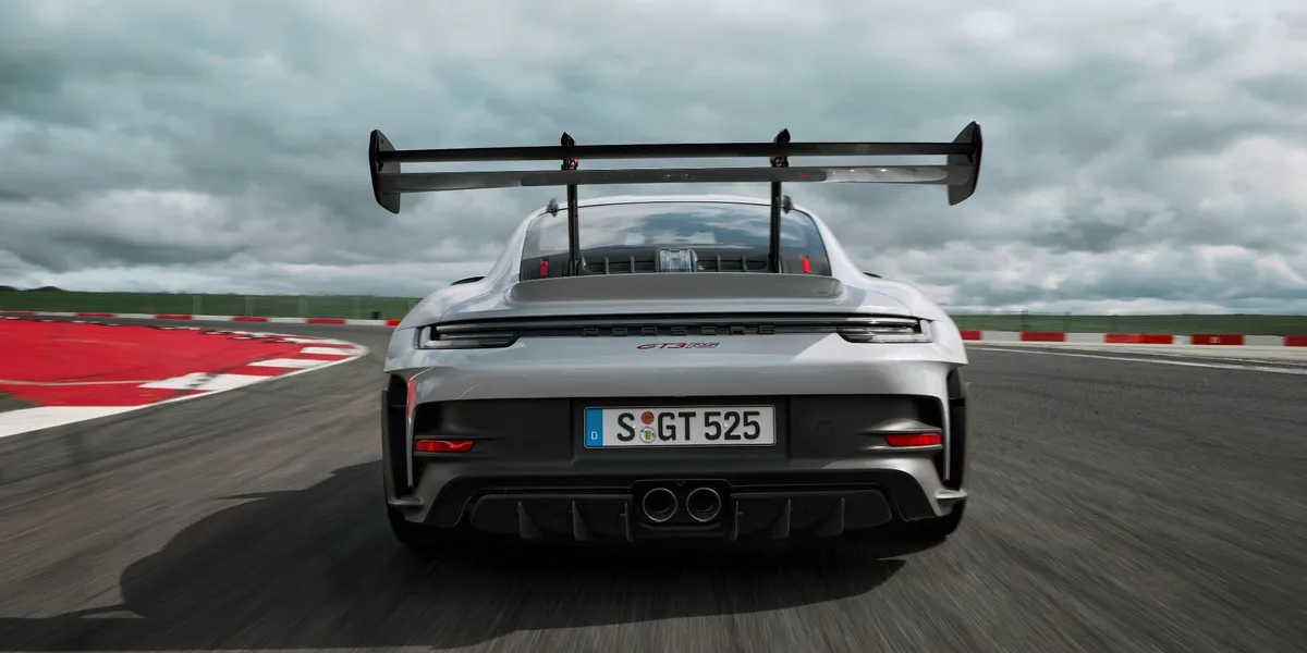 2026 Porsche 911 Carrera rear driving view under bridge by waterway
