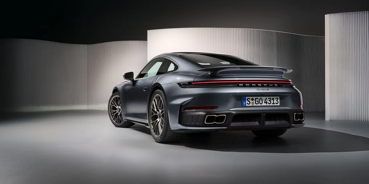 Rear view of 2026 Porsche 911 Turbo in metallic gray, highlighting quad exhaust and LED light bar.