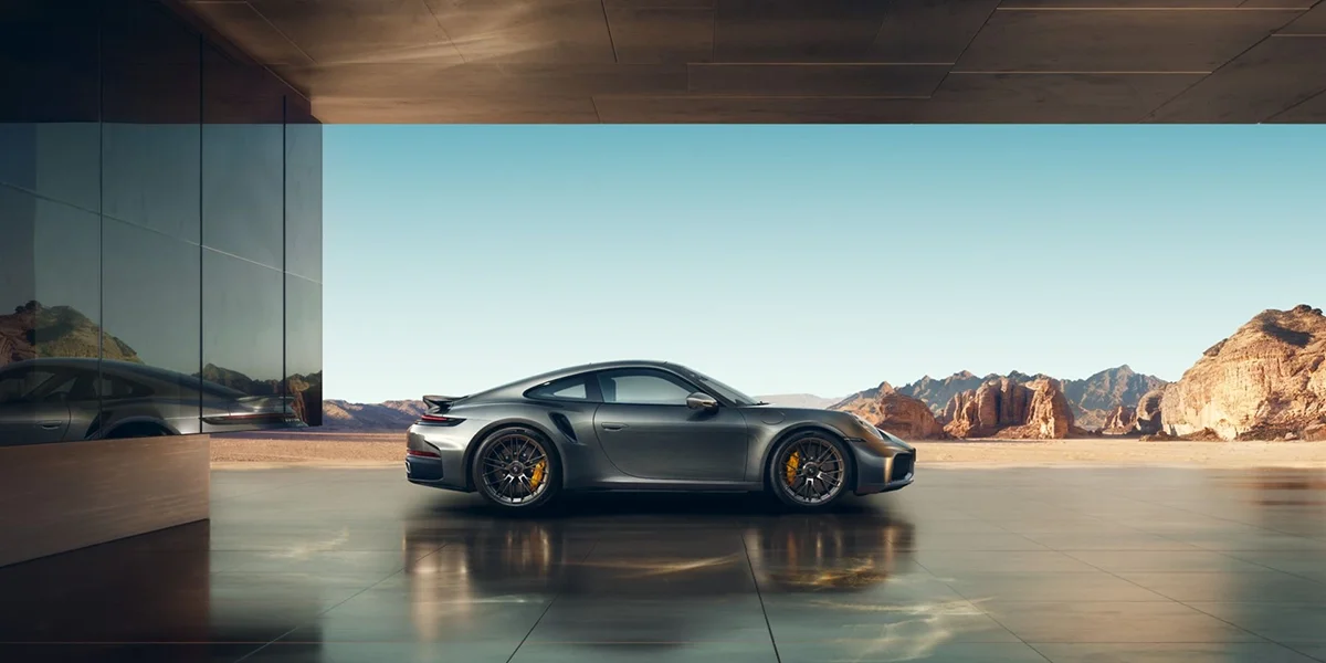 Side profile of 2026 Porsche 911 Turbo S coupe with carbon ceramic brakes in a desert setting.