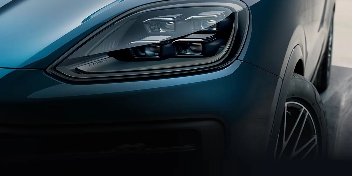 Detail of the 2026 Porsche Cayenne's LED matrix headlight unit and front fender.