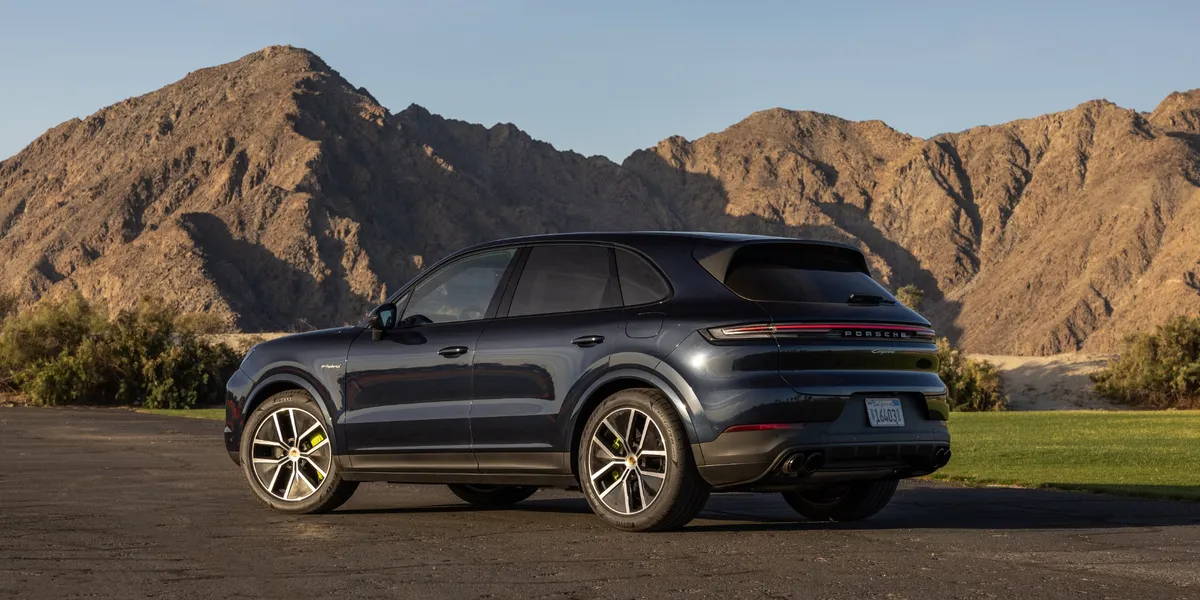  Three-quarter front view of the Porsche Cayenne E-Hybrid on a scenic plateau.