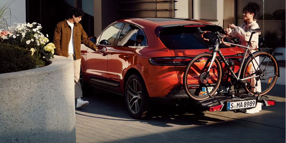 Red Porsche Macan GTS with rear bike rack, highlighting versatile SUV utility and active lifestyle design.