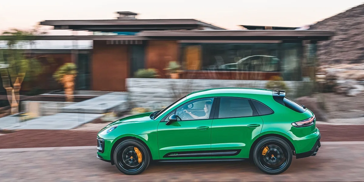 Python Green Porsche Macan GTS side profile in motion, showcasing bold styling and black performance wheels.