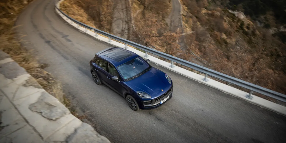 Top-down shot of Porsche Macan T driving on a winding mountain road