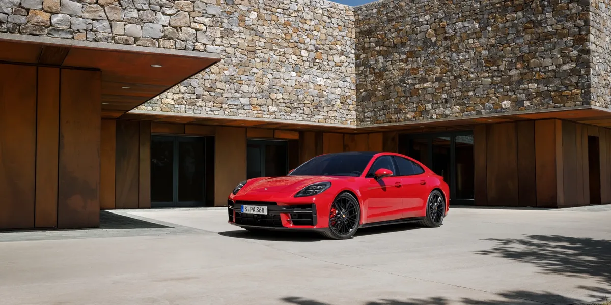 2026 Porsche Panamera GTS parked in front of a modern stone house