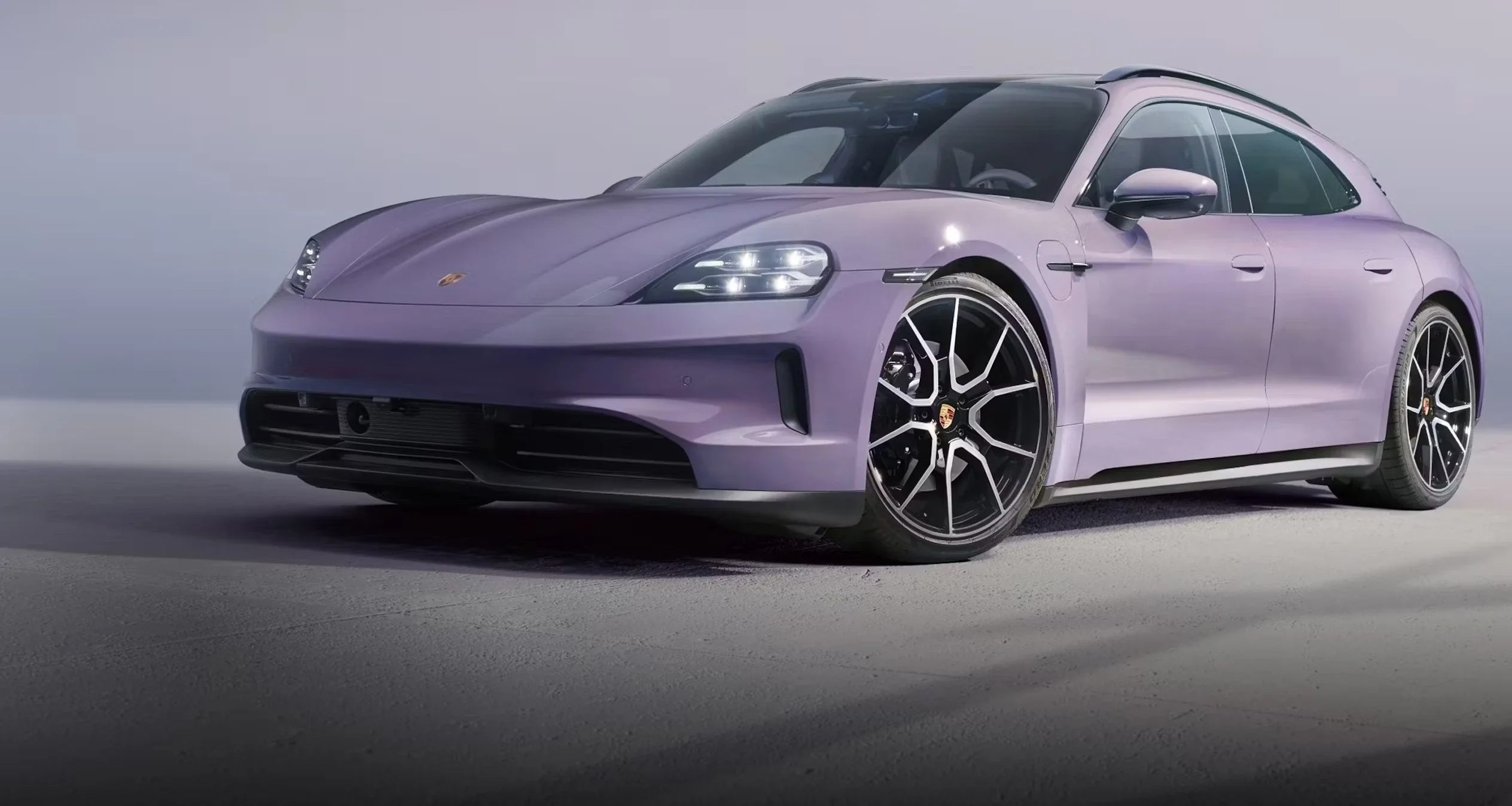 Porsche Taycan Cross Turismo in Jet Black Metallic driving at speed, showcasing electric performance and dynamic handling.