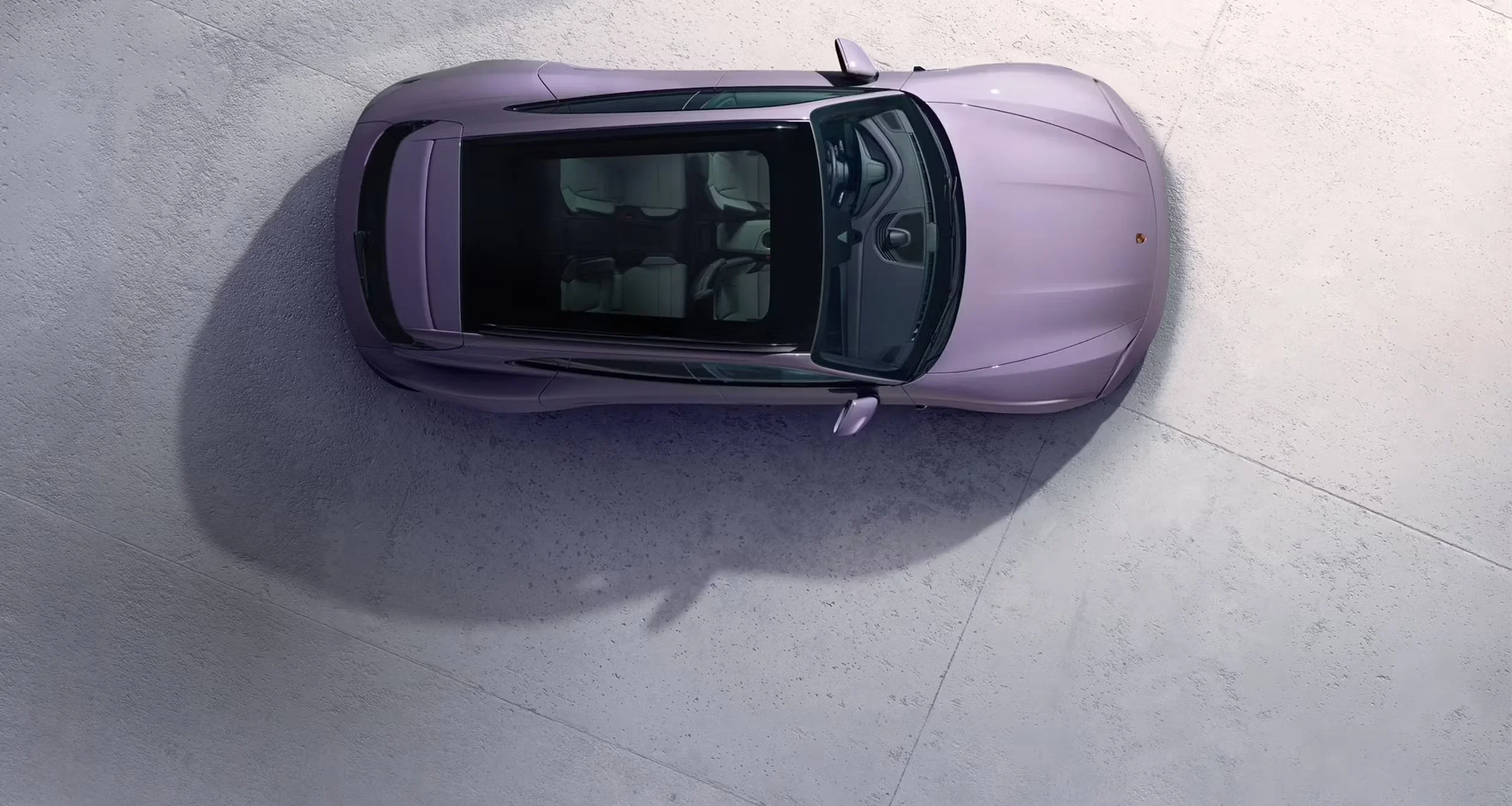 Passenger display screen in Porsche Taycan Cross Turismo featuring infotainment apps and Road to Le Mans film preview.