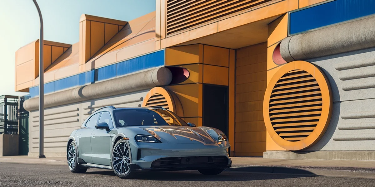 Passenger-side infotainment screen in Porsche Taycan displaying “Road to Le Mans” film promotion.