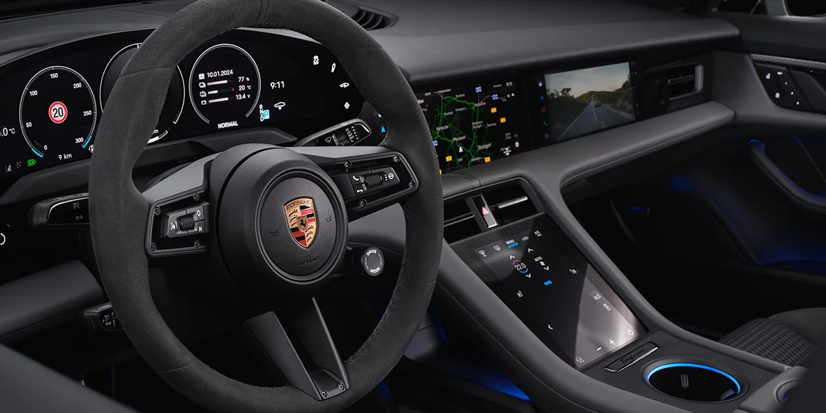 Close-up view of Porsche Taycan driver display cluster, sport chrono clock, and minimalist dashboard. 