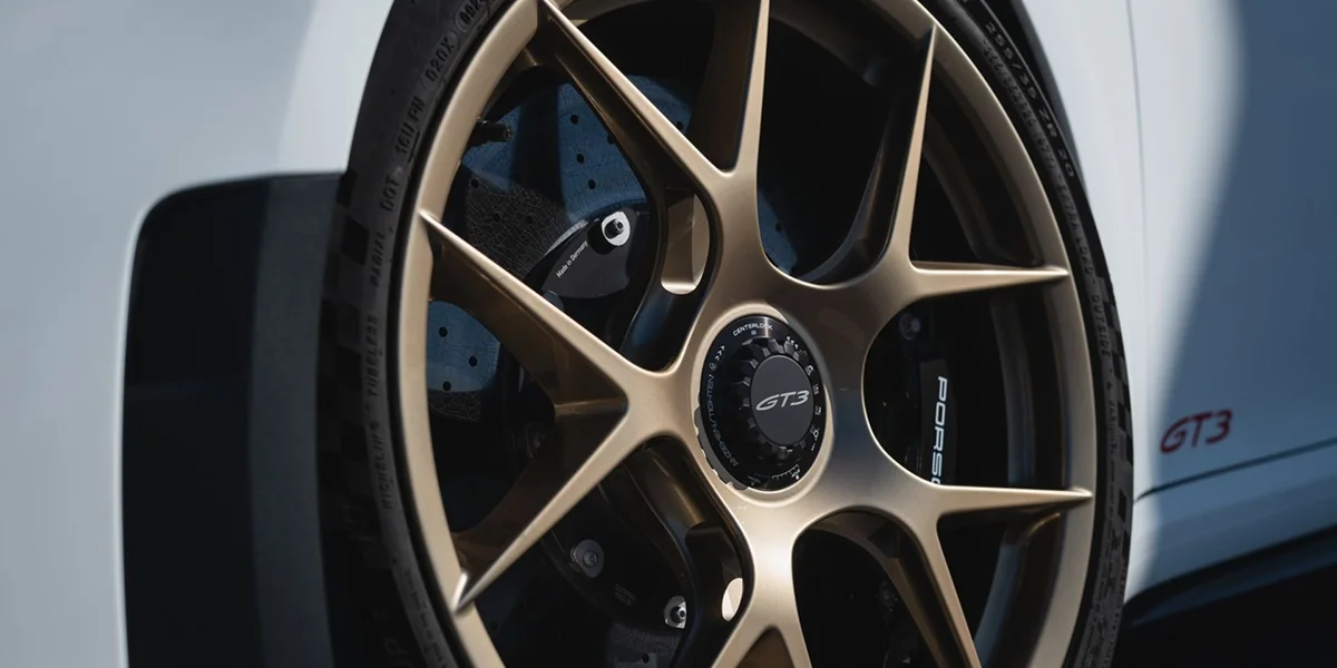 Porsche 911 GT3 rear three-quarter view at sunset, emphasizing wing and diffuser.