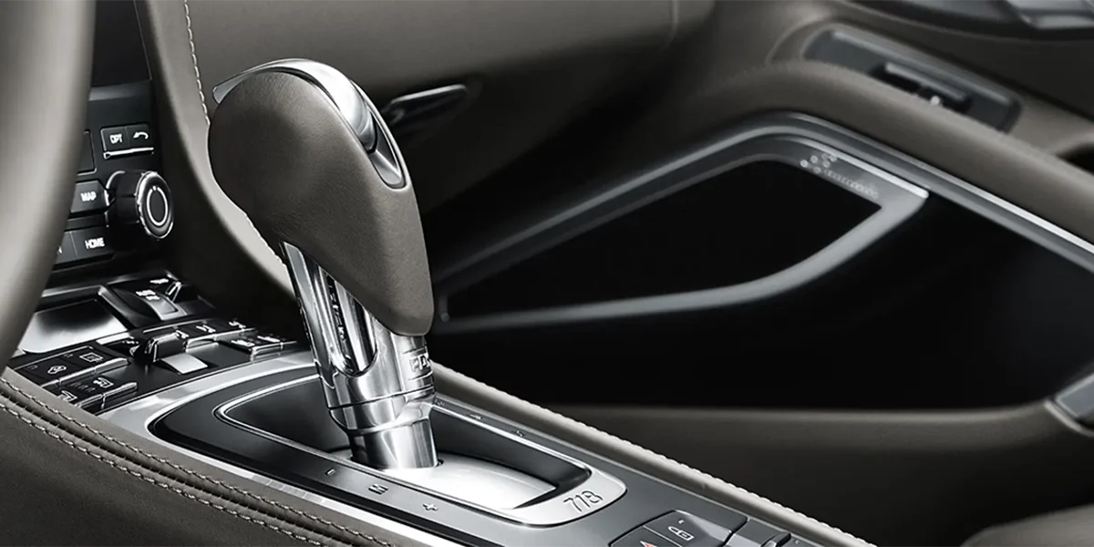 Porsche 718 Cayman driver-focused cockpit with sporty steering wheel, premium dashboard layout, and performance-centered controls.
