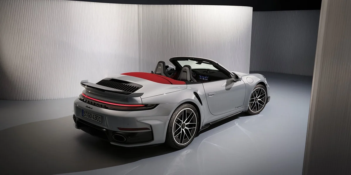 Overhead view of the Porsche 911 Turbo S Cabriolet with its doors open, red interior and roof details visible.