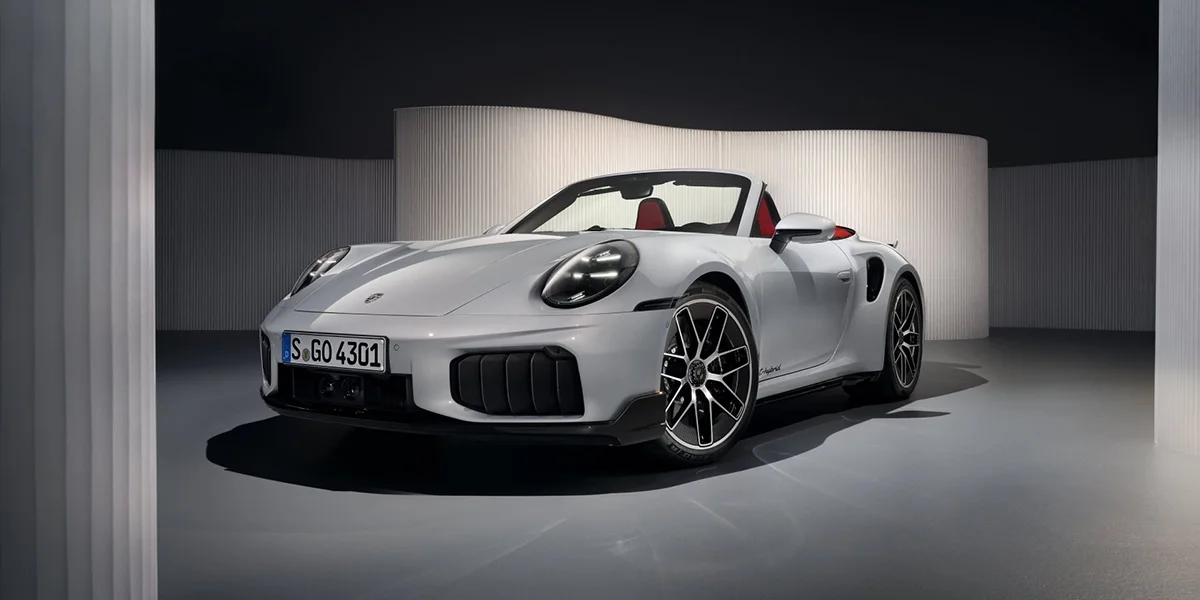 Interior view of the Porsche 911 Turbo S Cabriolet showing the dashboard, steering wheel, and modern digital displays. 