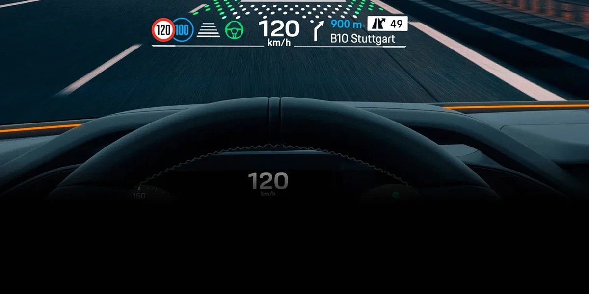 Porsche Cayenne head-up display showing speed, route guidance, and lane positioning on the road ahead.