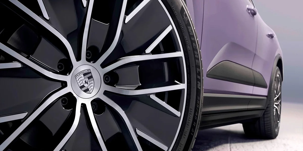 Close-up of the Porsche Macan Electric interior door panel with ambient lighting and controls.