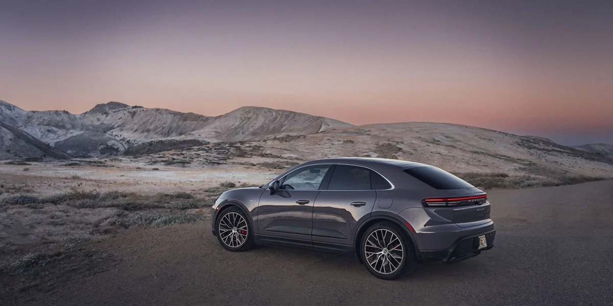 Side angle of the 2024 Porsche Macan 4S in gray metallic paint, highlighting sleek SUV proportions and alloy wheels.