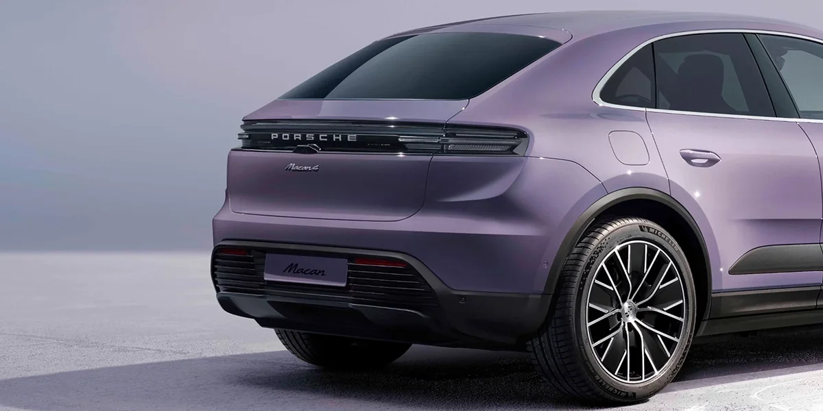 Rear three-quarter view of the Porsche Macan Electric showing the taillight bar and rear wheel.