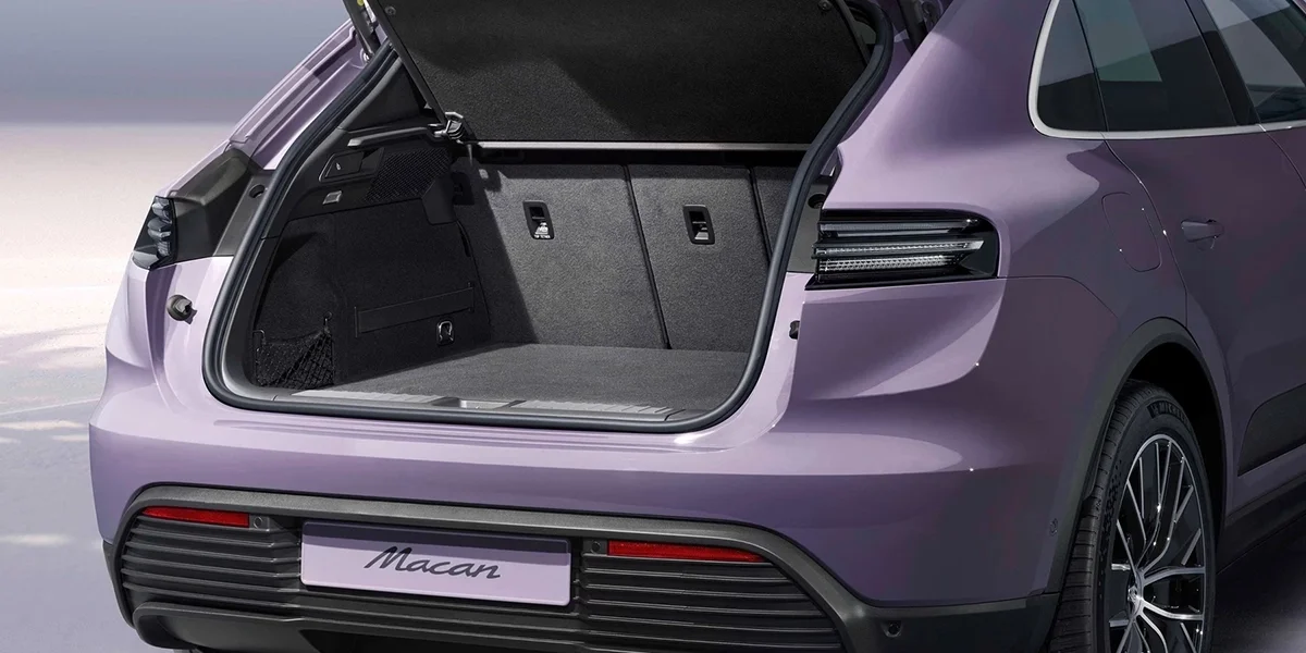 Open rear cargo area of the Porsche Macan Electric showing the trunk space and rear seats.