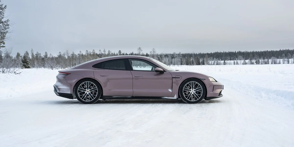 Close-up of Porsche crest emblem on the hood, highlighted under soft winter sunlight.