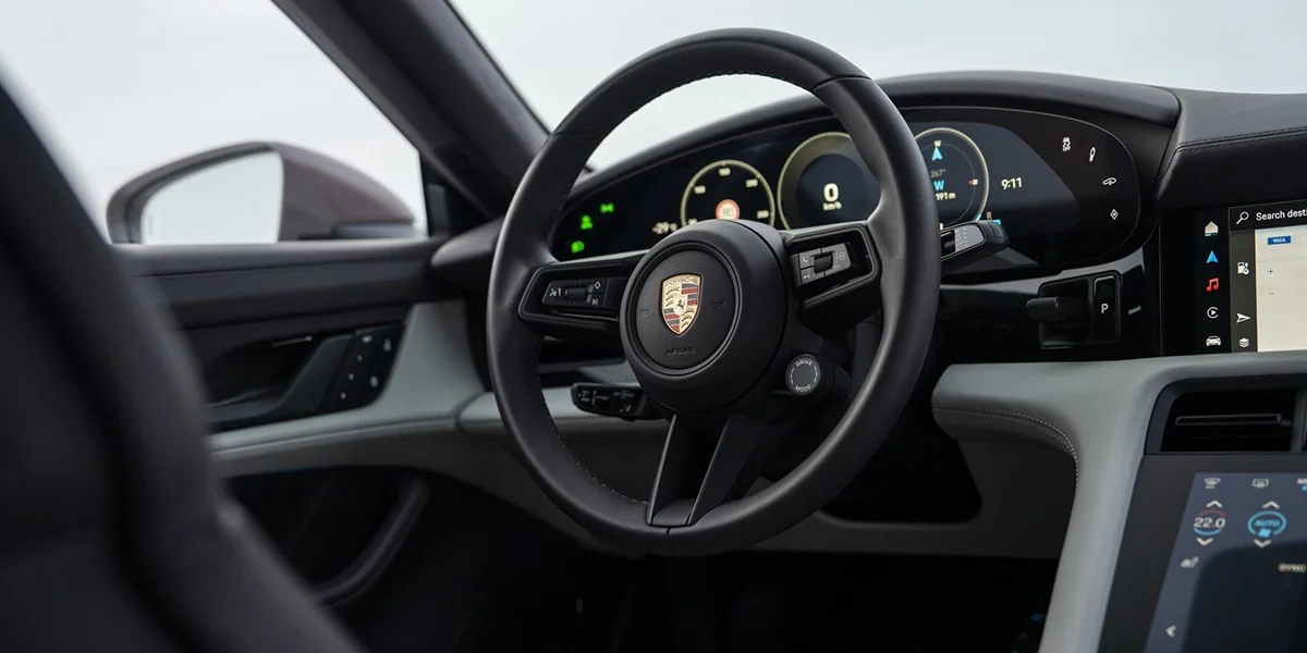 Porsche Taycan carving through snow, snow spray flying from rear wheels in a controlled drift.