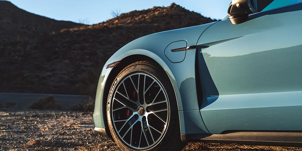 Overhead top view of the Porsche Taycan, emphasizing clean aerodynamic design lines and panoramic roof.