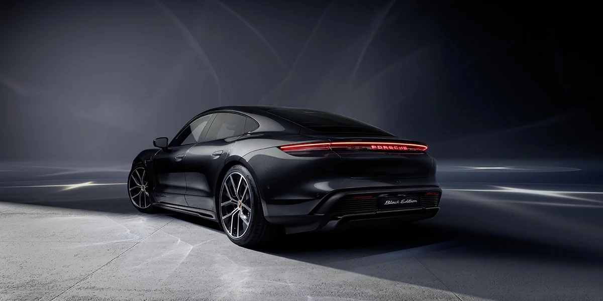 Overhead shot of Porsche Taycan with panoramic glass roof, contrasting with snow-covered terrain.