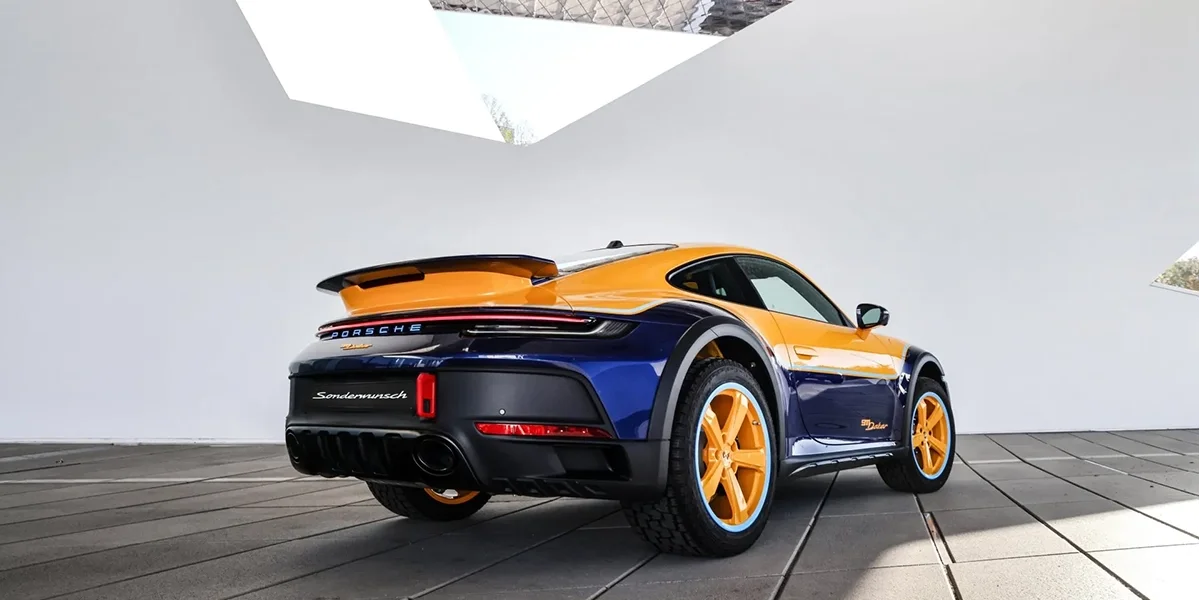 Rear three-quarter view of the Porsche 911 Dakar with raised suspension and off-road tires