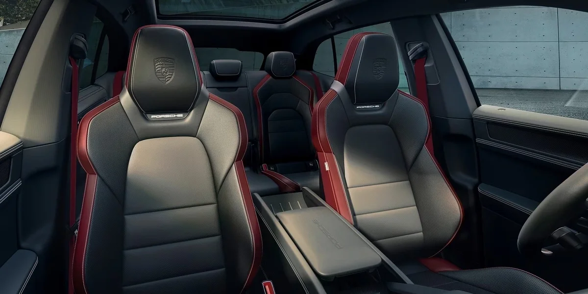Porsche Cayenne cabin featuring two-tone sport seats, panoramic roof, and premium materials.